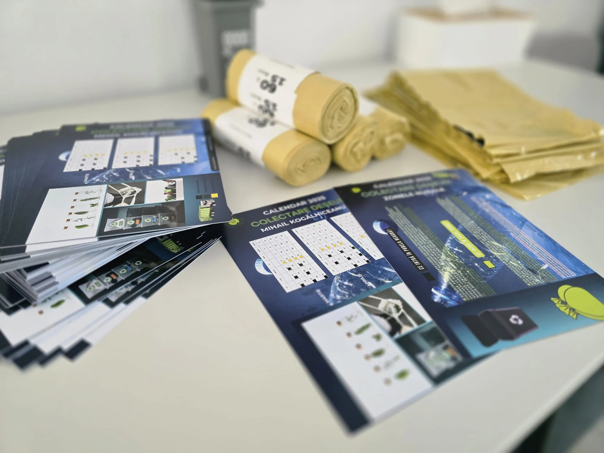 Materiale tipărite pentru calendarele de colectare a deșeurilor și saci galbeni distribuiți comunităților.