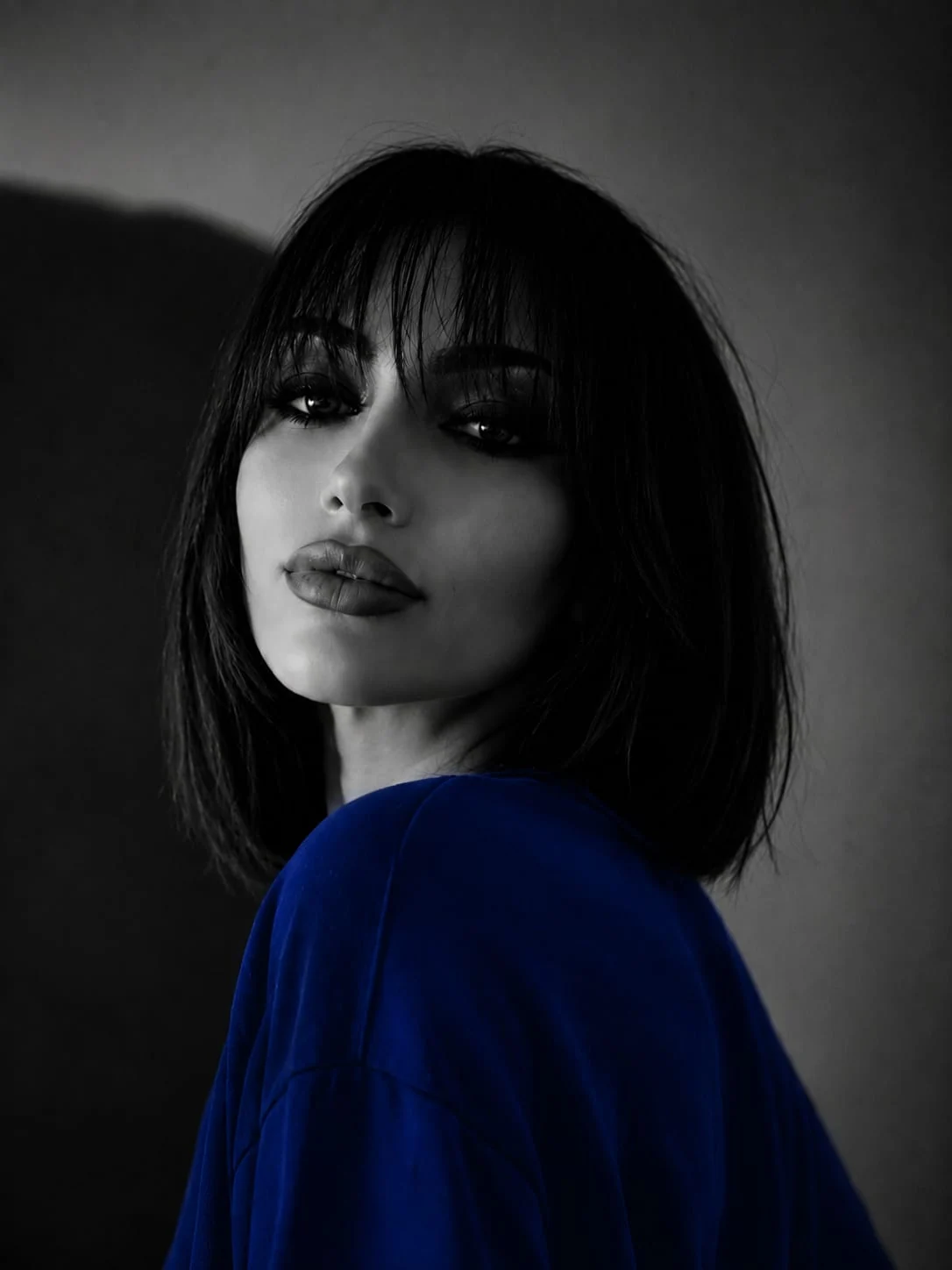 Portret alb-negru Aura cu accent cromatic albastru cobalt și lumină dramatică.